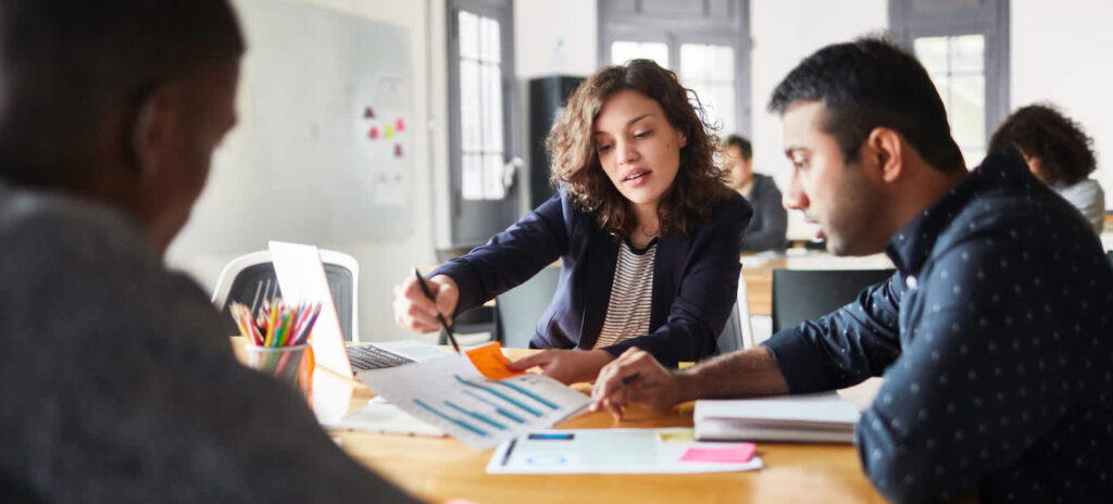 Business-professionals-discussing-over-a-graph-1127726411_8477x5651